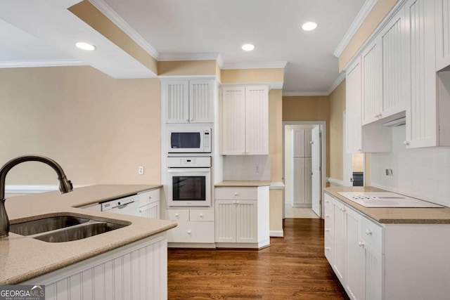 kitchen featuring white appliances, crown molding, dark wood-type flooring, sink, and white cabinetry