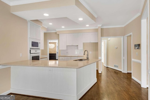 kitchen with white cabinets, white appliances, dark hardwood / wood-style floors, and sink