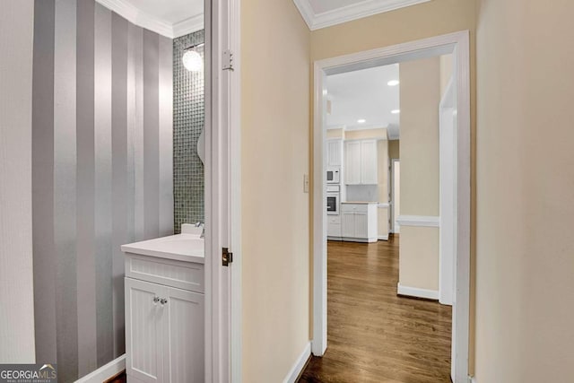 bathroom featuring vanity, wood-type flooring, and ornamental molding