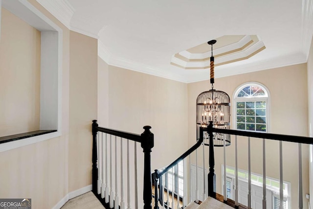 hall with light colored carpet, a chandelier, and ornamental molding