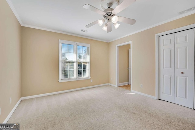 unfurnished bedroom with ceiling fan, crown molding, light carpet, and a closet