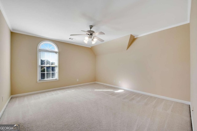 spare room featuring lofted ceiling, light colored carpet, ceiling fan, and ornamental molding