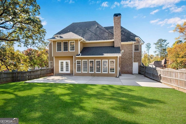 rear view of house with a lawn, a patio area, and french doors