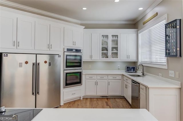 kitchen featuring white cabinetry, ornamental molding, and appliances with stainless steel finishes