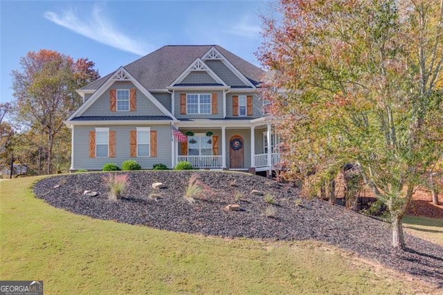 view of front of house with covered porch and a front lawn