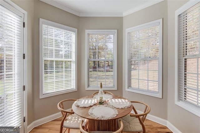 dining space with light hardwood / wood-style floors and crown molding