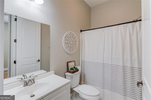 bathroom featuring a shower with shower curtain, vanity, and toilet