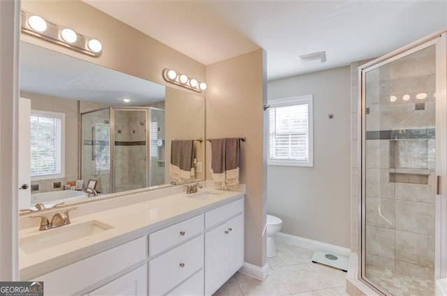 bathroom featuring tile patterned flooring, vanity, toilet, and a shower with shower door