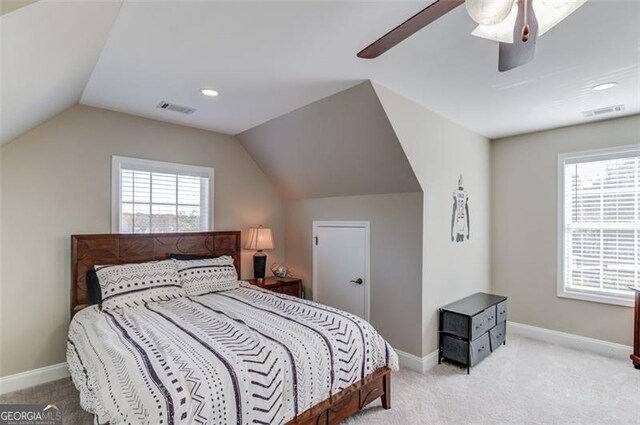 bedroom with ceiling fan, light colored carpet, and lofted ceiling