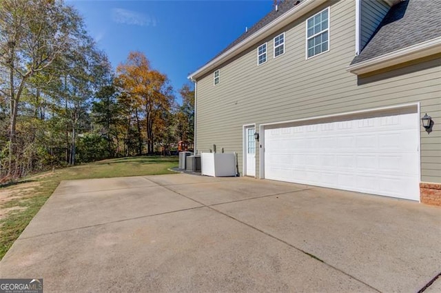 view of side of home featuring a lawn and a garage