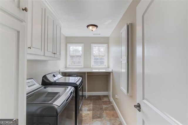 laundry area with separate washer and dryer and cabinets