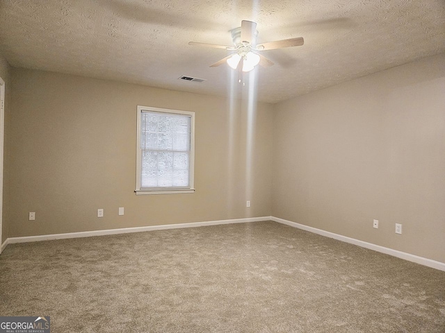 carpeted spare room with a textured ceiling and ceiling fan