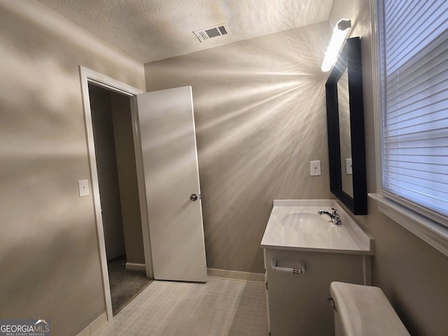 bathroom featuring vanity, tile patterned floors, and a textured ceiling