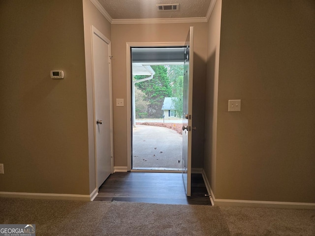 doorway with crown molding and a textured ceiling