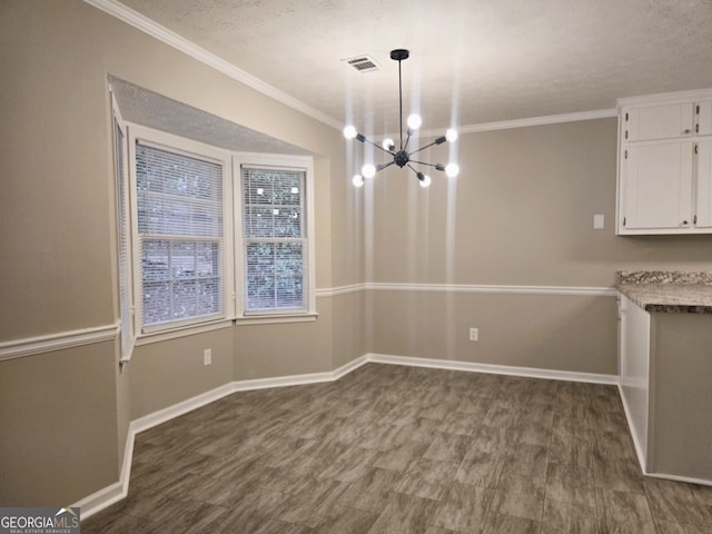 unfurnished dining area with an inviting chandelier, a textured ceiling, and ornamental molding