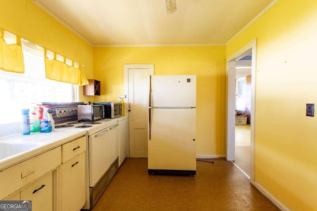 kitchen featuring stove, white fridge, and crown molding