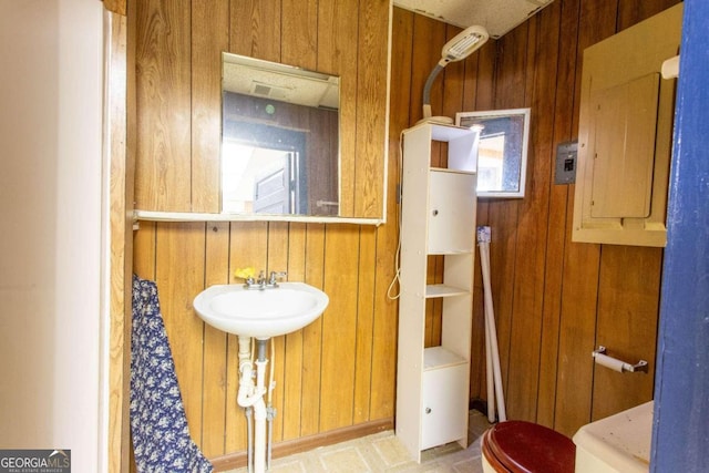 bathroom featuring electric panel and wooden walls