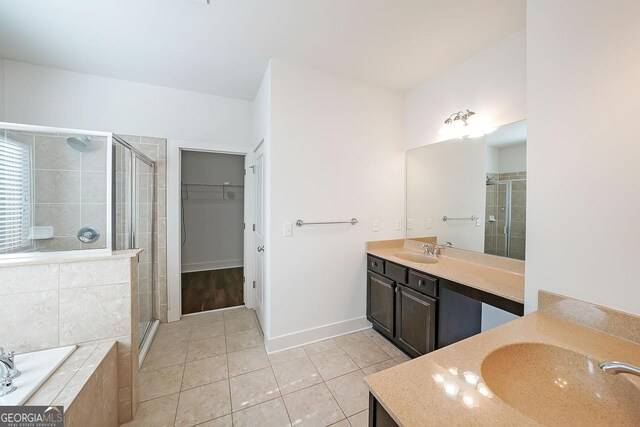 bathroom featuring shower with separate bathtub, vanity, and tile patterned floors