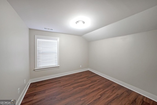 additional living space with dark wood-type flooring and lofted ceiling