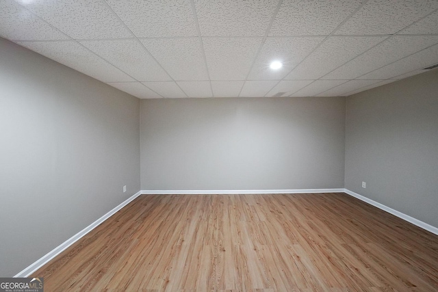 unfurnished room featuring hardwood / wood-style flooring and a drop ceiling