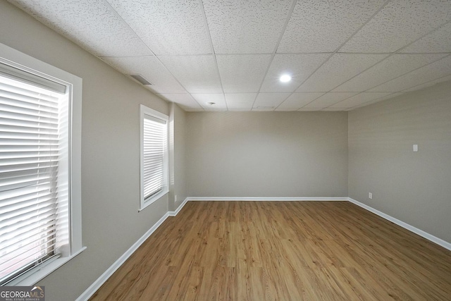 spare room featuring a paneled ceiling and hardwood / wood-style floors