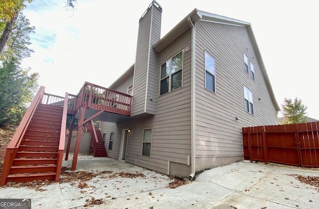 view of side of home featuring a wooden deck and a patio