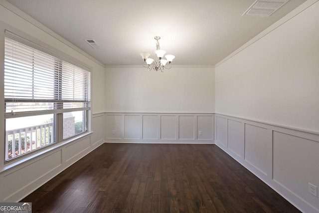 spare room featuring ornamental molding, dark hardwood / wood-style floors, and a notable chandelier