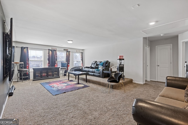 living room featuring carpet, attic access, and baseboards