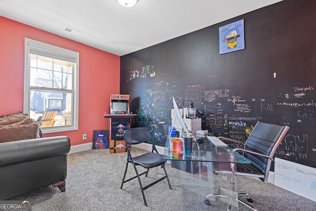 office area with baseboards, an accent wall, and visible vents