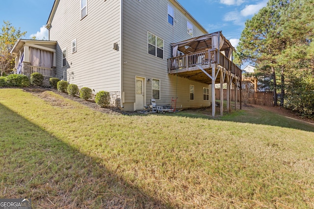 back of house featuring a lawn and a wooden deck