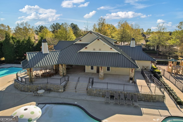 outdoor pool with a patio and fence