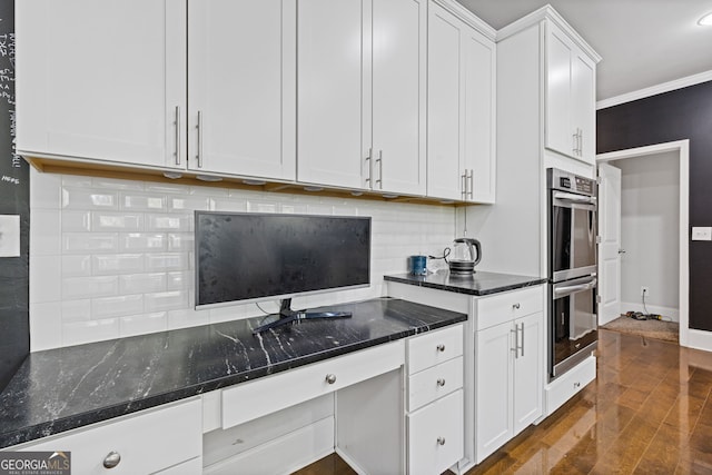 kitchen with tasteful backsplash, double oven, dark wood-type flooring, white cabinets, and dark stone countertops