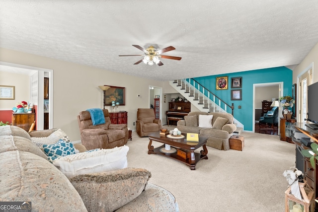 carpeted living room featuring ceiling fan and a textured ceiling