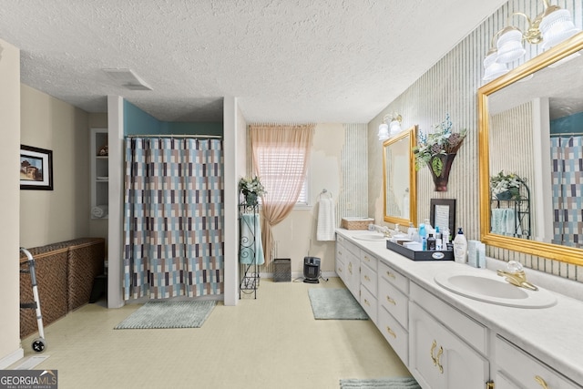 bathroom with vanity, curtained shower, and a textured ceiling