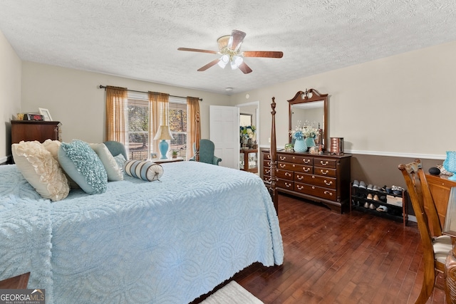 bedroom with a textured ceiling, ceiling fan, and dark wood-type flooring