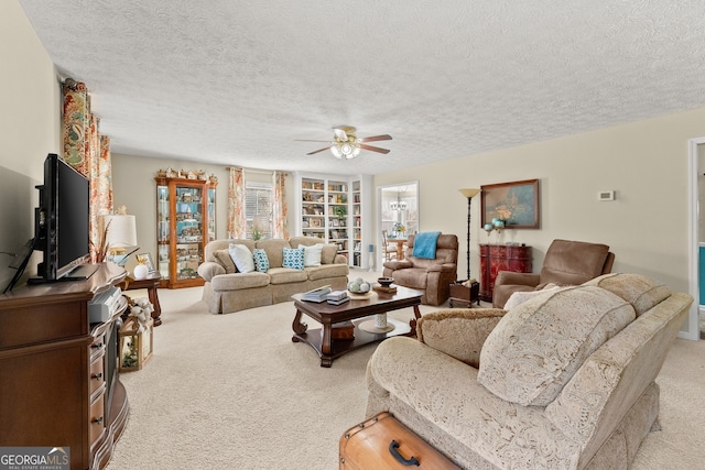 living room with a textured ceiling, light colored carpet, and ceiling fan