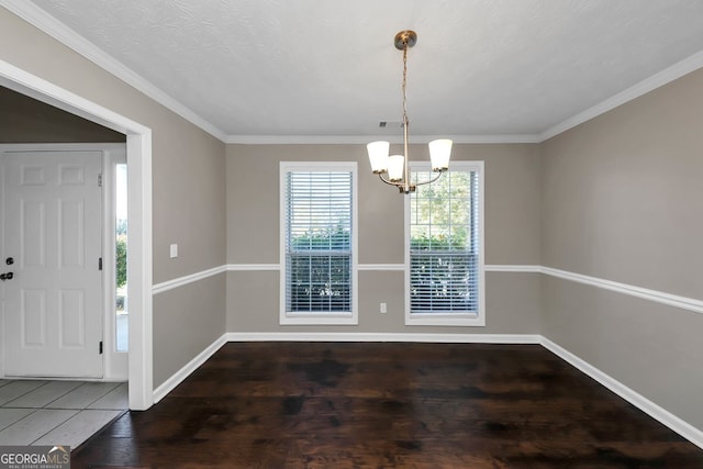 unfurnished dining area with a chandelier, a textured ceiling, dark hardwood / wood-style floors, and crown molding