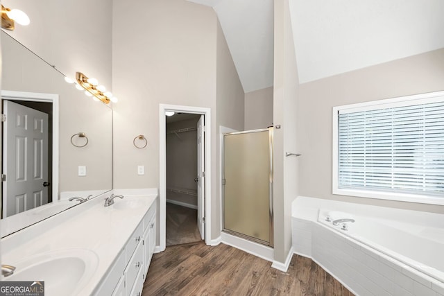 bathroom with hardwood / wood-style floors, vanity, shower with separate bathtub, and high vaulted ceiling