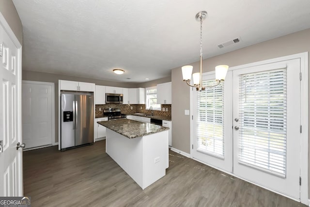 kitchen with pendant lighting, a healthy amount of sunlight, and appliances with stainless steel finishes