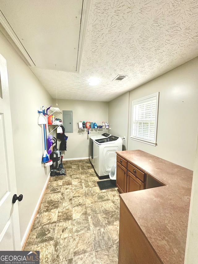 washroom with cabinets, independent washer and dryer, a textured ceiling, and electric panel