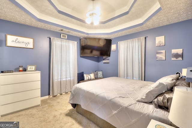 carpeted bedroom featuring a raised ceiling, ceiling fan, and ornamental molding