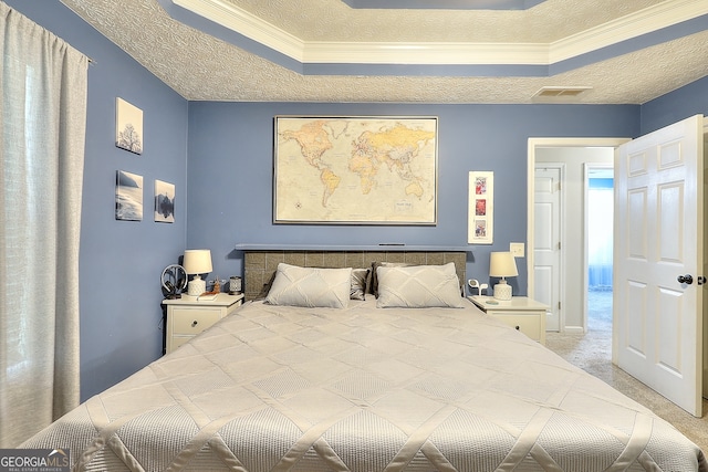 bedroom featuring light carpet, a textured ceiling, a tray ceiling, and ornamental molding