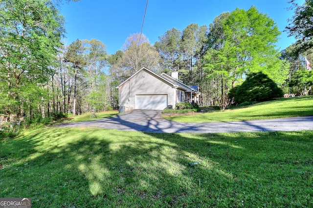 view of side of property featuring a garage and a lawn