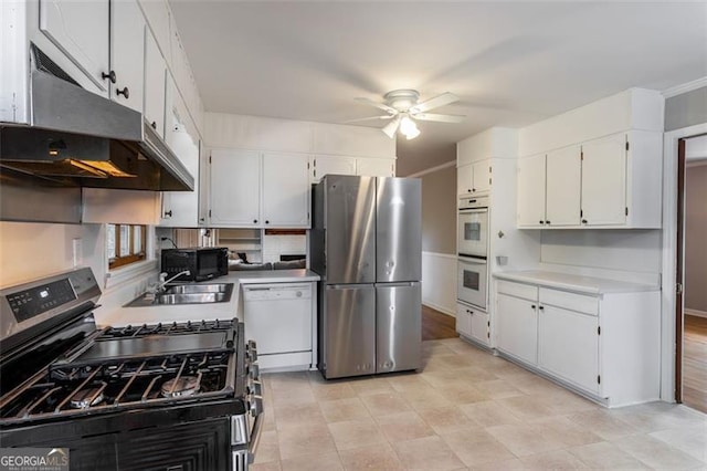 kitchen with backsplash, white cabinets, sink, ceiling fan, and appliances with stainless steel finishes