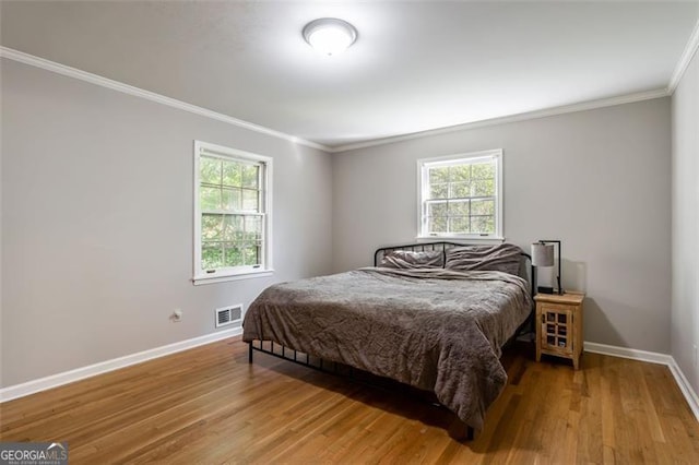 bedroom with wood-type flooring and ornamental molding