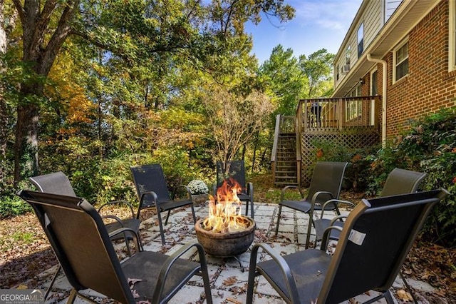 view of patio / terrace with a deck and an outdoor fire pit