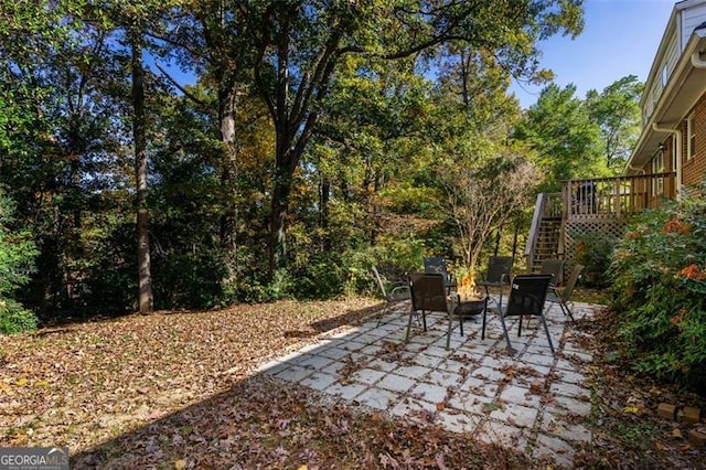 view of patio with an outdoor fire pit and a wooden deck