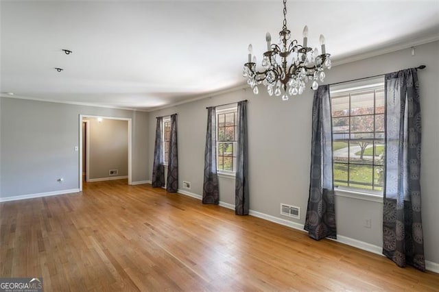 unfurnished room featuring light hardwood / wood-style floors, crown molding, and a wealth of natural light