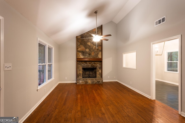 unfurnished living room with ceiling fan, dark wood-type flooring, high vaulted ceiling, and a fireplace