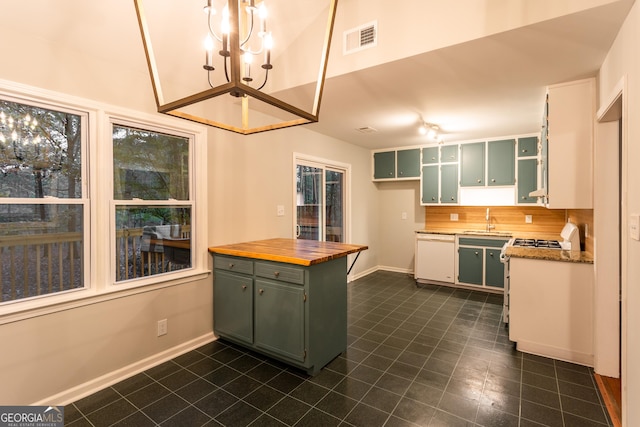 kitchen with white appliances, green cabinetry, a chandelier, white cabinets, and sink